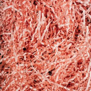 From above heap of shredded crinkled pink paper filler for gift box as abstract background